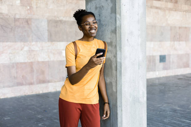 Portrait of a young African American woman using smartphone outdoors